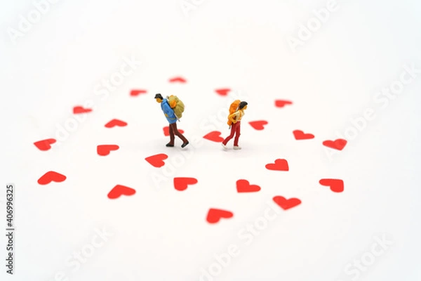 Fototapeta Miniature people standing with Heart shaped red paper. Red heart is the promise of love.  as background Valentine concept with copy spaces for your text or design.