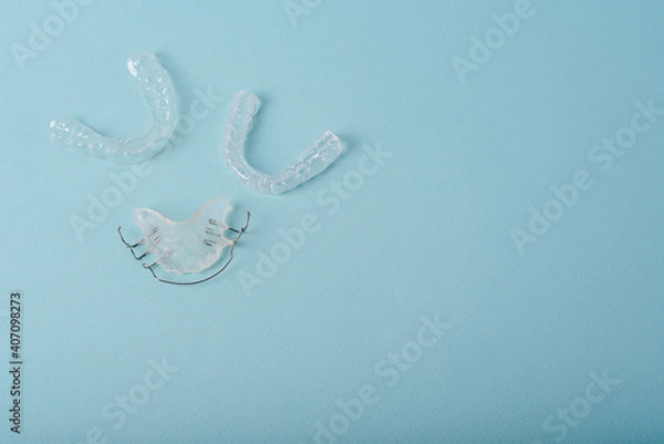 Fototapeta Invisalign braces or invisible retainer on blue background. Ortodontic model brace or bracket.