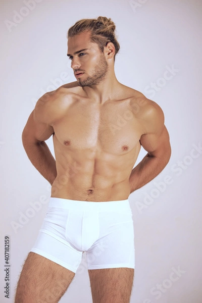 Obraz Sexy sport muscle strongface blond guy with long hair in white underwear on white isolated  font background