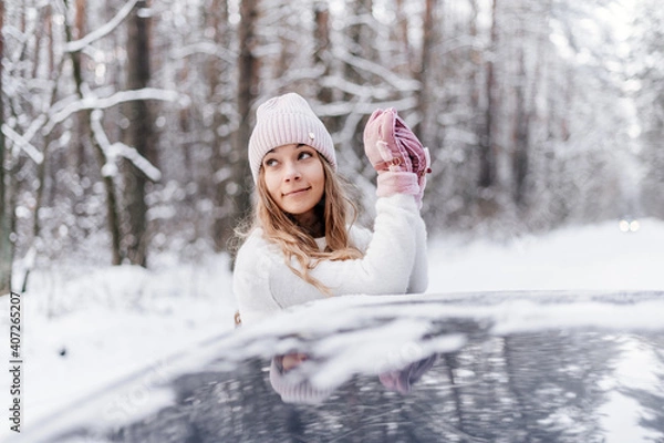 Obraz young girl in winter forest smiles and looks up in car