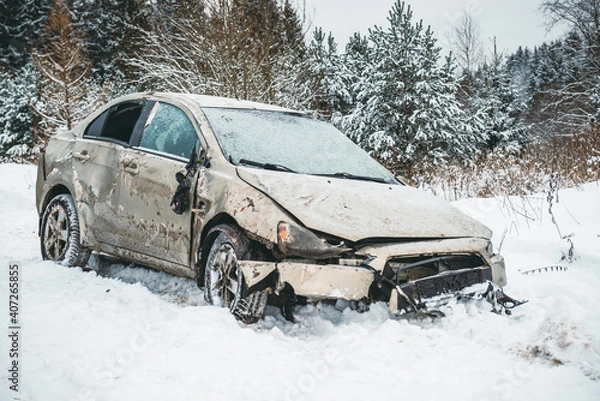 Fototapeta The car overturned on a snowy road and got on its wheels. A broken car after an accident that flew off the road at high speed.