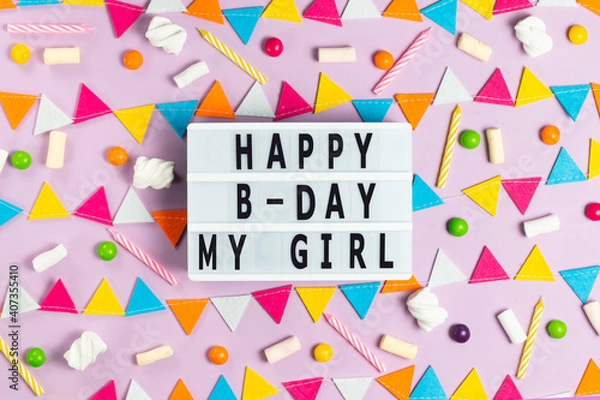 Fototapeta White board with the inscription happy birthday my girl on a pink background with a multi-colored garland of felt, candles, candies and marshmallows greeting card