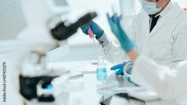 Fototapeta close up. scientists examining liquid samples in the lab.