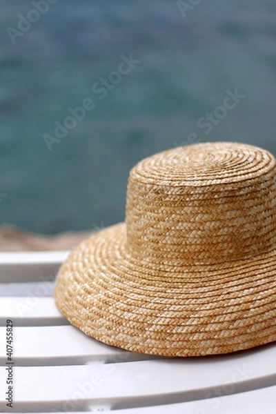 Obraz Straw hat on the deck chair by the water. Selective focus.