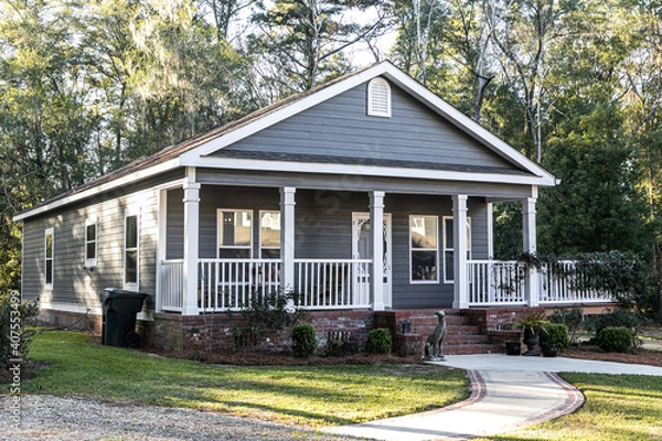 Fototapeta Close up of small blue gray mobile home with a front and side porch with white railing