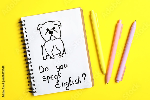 Fototapeta Notebook with question Do You Speak English and pens on yellow background, flat lay