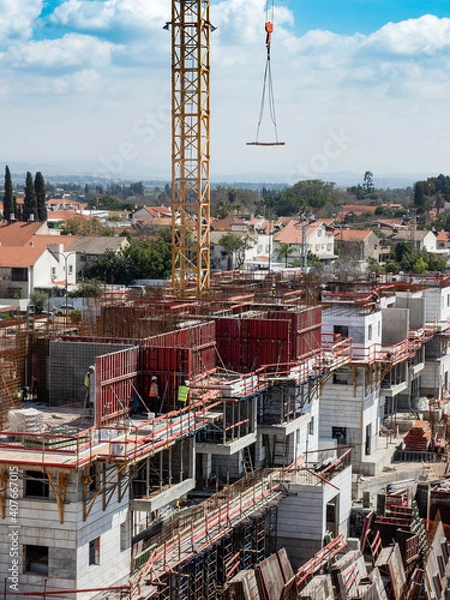 Fototapeta Construction crane on the construction site of a high-rise building