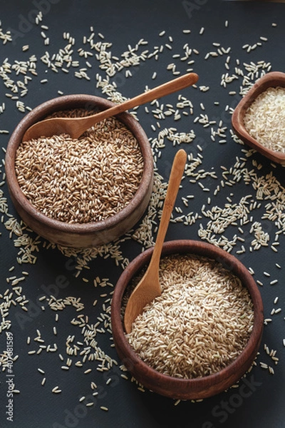 Obraz Set of different types of rice and cereals in wooden bowls and bamboo spoon