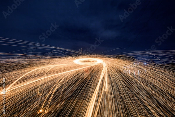 Fototapeta silhouette man making circle sparks night