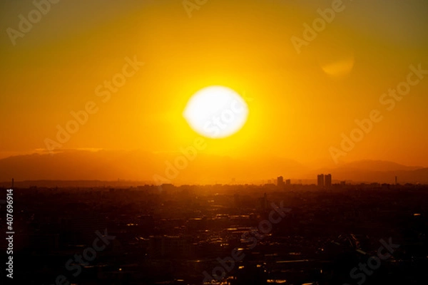 Obraz 冬の東京の夕暮れの街並みと巨大な夕日