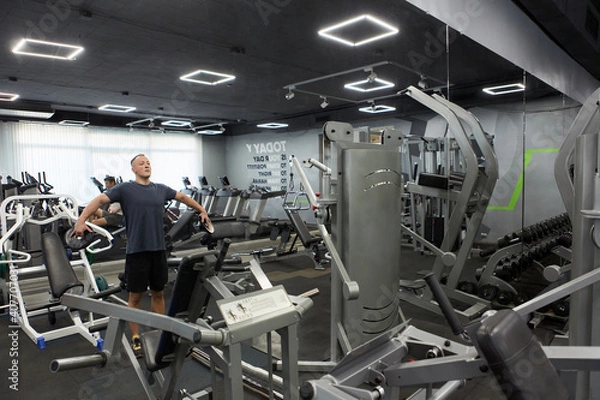 Fototapeta Man in the training gym  working hard after quarantine.