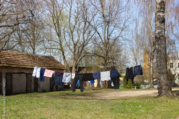 Fototapeta Laundery drying outside. Clothes hanging on the rope in the garden.