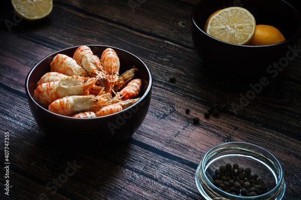 Fototapeta Greenlandic shrimps. Boiled shrimp on a dark background with lemon and spices.Preparation of a dietary dish . Protein products. Source of omega 3 and omega 6 acids.