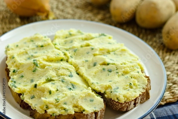 Fototapeta Two slices of peasant bread with German potato spread Kartoffelkäse on a plate