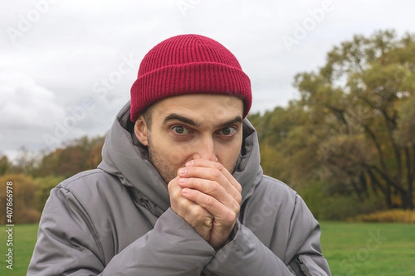 Fototapeta Person freezes on the street, a man is warmly dressed on an autumn seasonal day, portrait, close-up
