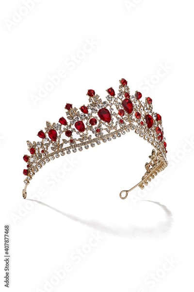 Fototapeta Subject shot of golden tiara adorned with a plenty of ruby gems and clear sparkling rhinestones that form fanciful pattern. The luxury queen crown is isolated on the white backdrop.