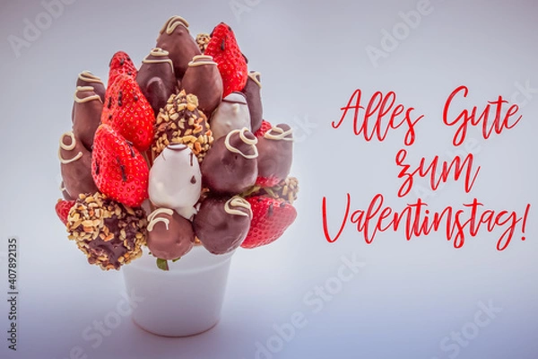 Fototapeta Happy valentine's day greeting card in German that reads Alles Gute zum Valentinstag with red lettering; A bundle of edible flowers, arrangement of strawberries covered in chocolate isolated on white