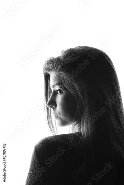 Fototapeta Black and white portrait of a young girl with sparkles on her face in a sweater on a white background