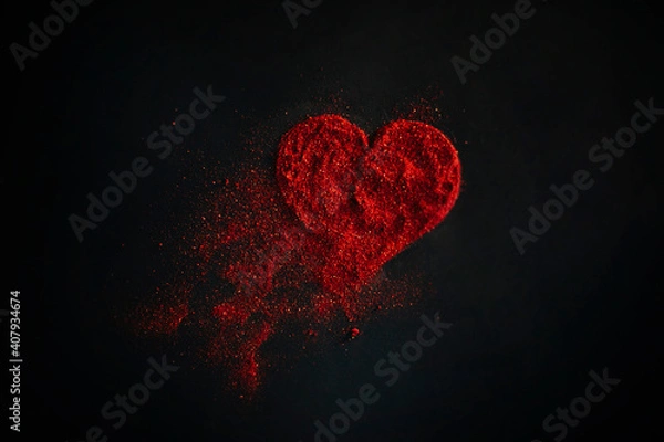 Fototapeta Scattered red heart made of sparkles on a black background. Shimmering dust symbol.