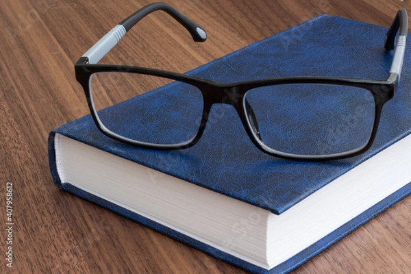 Obraz black glasses with a book
