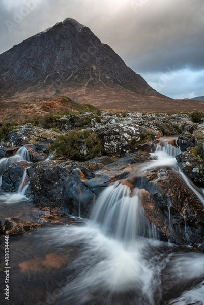 Fototapeta Epic landscape image of Buachaille Etive Mor waterfall in Scottish highlands on a Winter morning with long exposure for smooth flowing water
