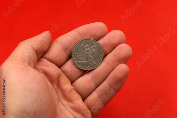 Fototapeta The soviet coin ruble in hand on red background
