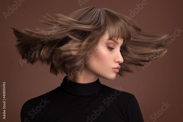 Obraz Portrait of a beautiful brown-haired woman with a short haircut on a brown background