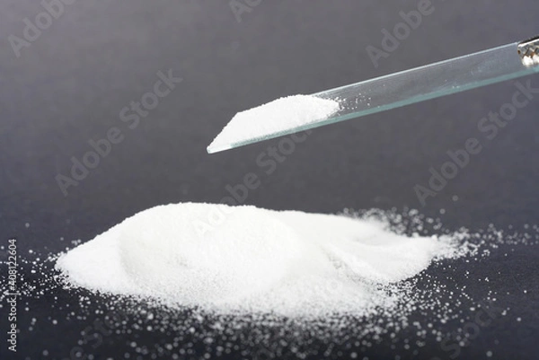 Fototapeta Makrogol powder photographed against a black background in the studio