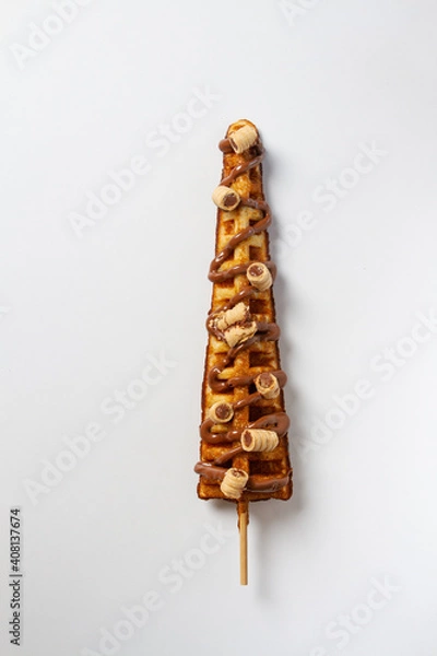 Fototapeta Waffles Stick, glazed with chocolate, topping rolled wafer filled with hazelnut and chocolate. White background