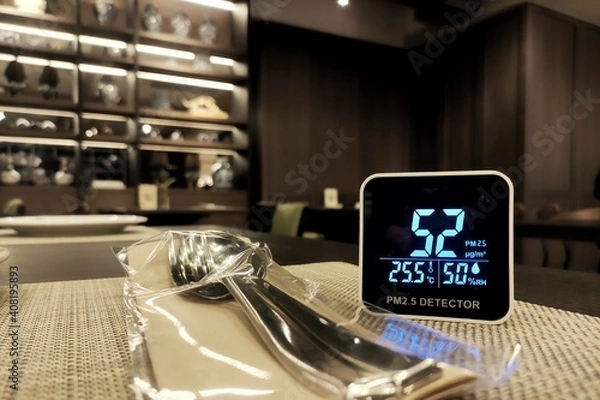 Obraz bad indoor air quality. small pm 2.5 sensor detect harmful amount of small dust particulate matter in a restaurant. enclosed space is not safe from harmful small dust.