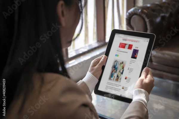 Fototapeta Closeup businesswoman reading news fashion or articles on website on the screen in smart taplet , internet networking concept