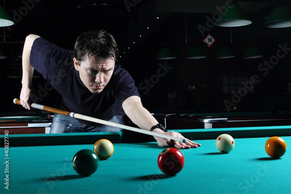 Obraz Man learning to play snooker in the dark club.