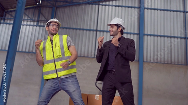 Obraz Warehouse worker and manager dancing in a large warehouse
