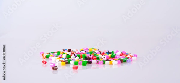 Obraz Play beads scattered on white background