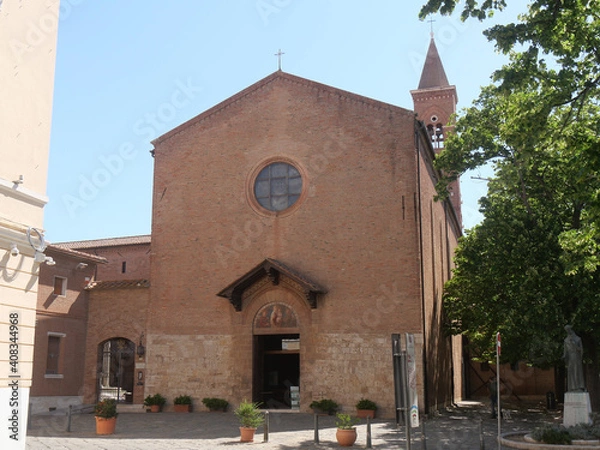 Fototapeta San Francesco Church in Grosseto, the facade with the portal characterized by a lunette with a fresco surmounted and protected by a wooden tabernacle, above which there is a rose window.