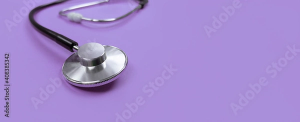 Obraz Black stethoscope on purple background with copy space.