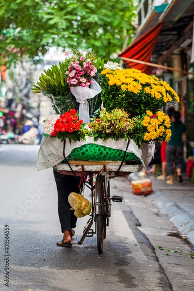 Fototapeta Hanoi, Vietnam - june 12, 2019: Old quarter of hanoi. Street sellers sell fruit from their bikes in traditional hats