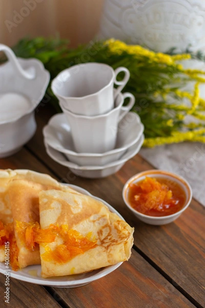 Fototapeta Thin pancakes with orange jam or marmalade on wooden background. Tasty breakfast. Maslenitsa.