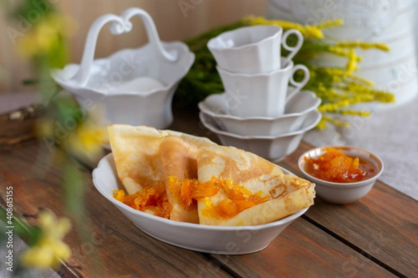 Obraz Thin pancakes with orange jam or marmalade on wooden background. Tasty breakfast. Maslenitsa.