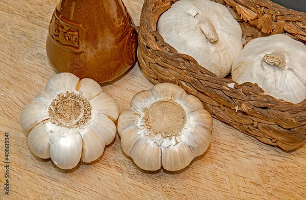 Fototapeta Fresh garlic on the wooden table and wicker basket,
Selective focus.
Top side view.
