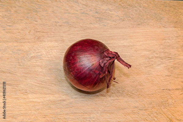 Fototapeta One red onion on light wooden table background with copy space for text.
Top view.