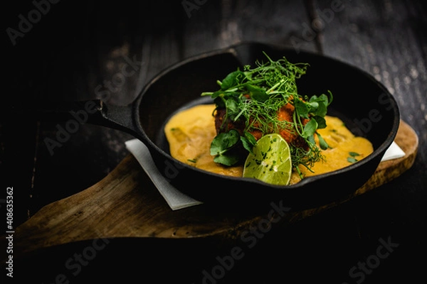 Fototapeta Smoked Haddock and Chive Fishcakes served with mixed baby leaf salad and creamed cheesy leek sauce
