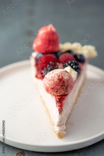 Fototapeta Slice of winter berry eton mess cheesecake with strawberries on a plate with a fork