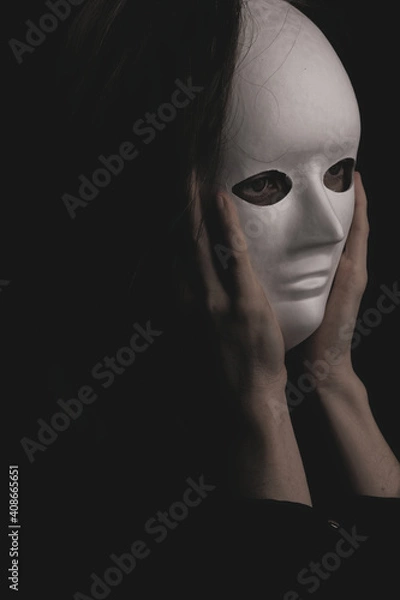 Fototapeta portrait of a woman in a white mask in the dark