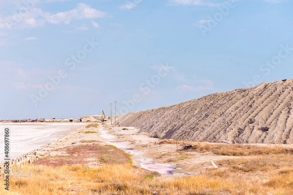 Fototapeta People gathering salt of pink salty Siwash Lake, colored by microalgae, famous for antioxidant properties, enriching water by beta-carotene at sunset