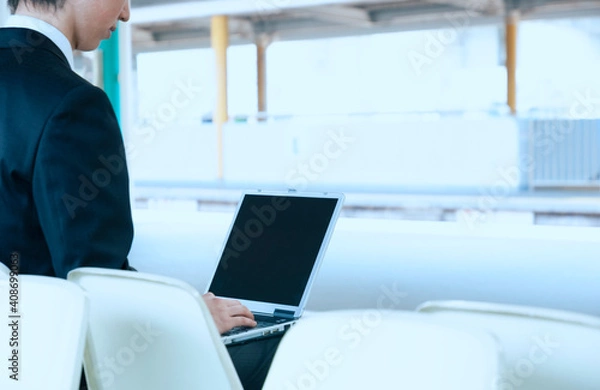 Fototapeta 駅のホームでパソコンをするビジネスマン