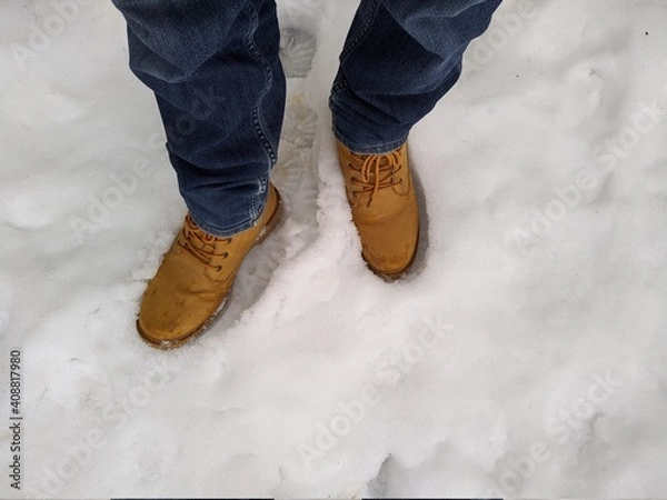 Fototapeta first person view man bend down the head looking for his boots standing on snow
