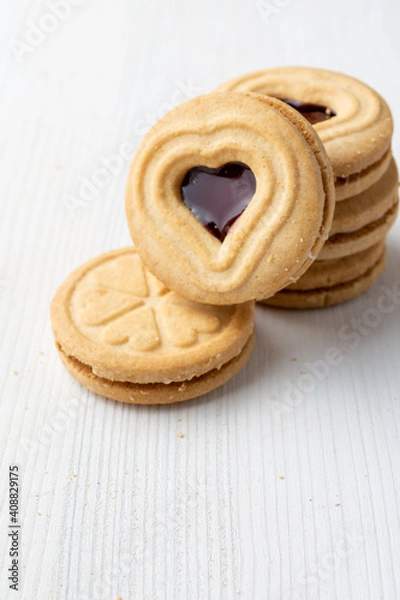 Fototapeta Top view of heart-shaped cookies on white table, vertically, with copy space