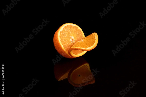 Obraz half orange with a slice on black