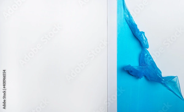 Fototapeta Flat gray rectangular object with peeled off blue protective film